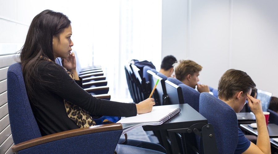 A primary school student sits at a desk taking notes during a lesson, highlighting the everyday classroom environment at the centre of the teacher’s safeguarding dispute.
