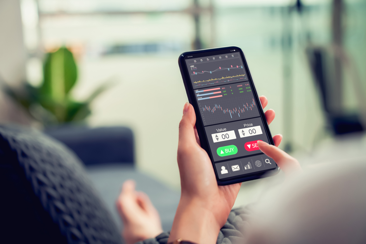Businesswoman using investor trading app at home