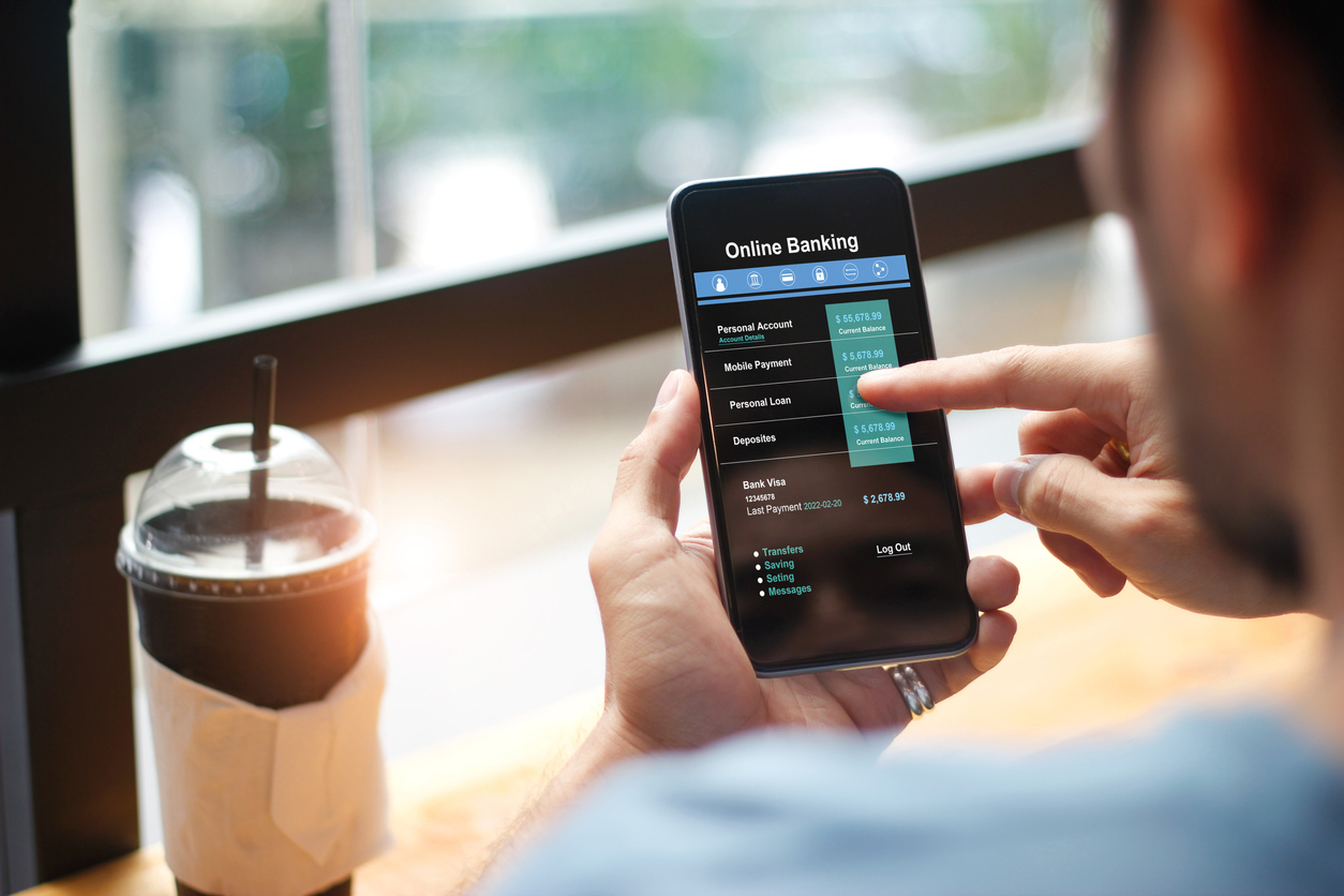 Man in cafe using digital banking app on a smartphone
