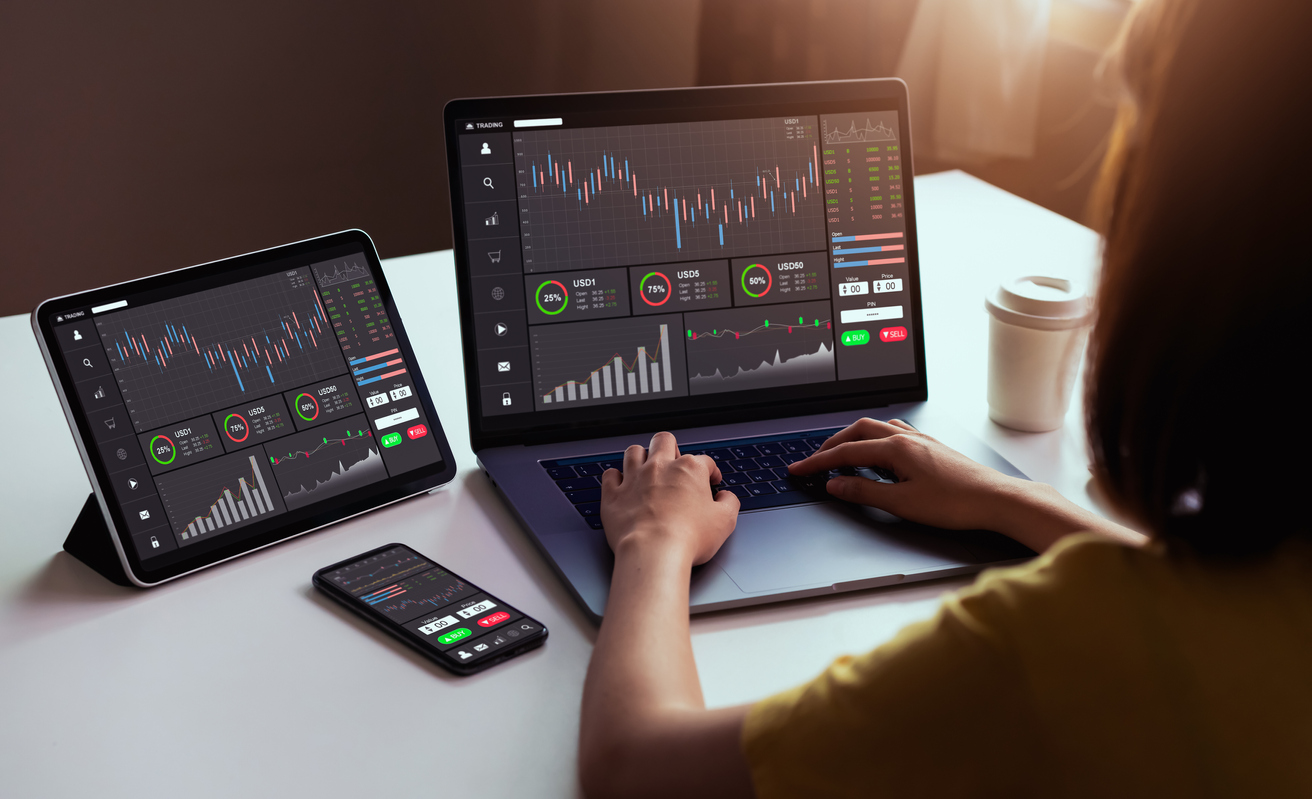 Businesswoman using trading service on laptop, smartphone and tablet