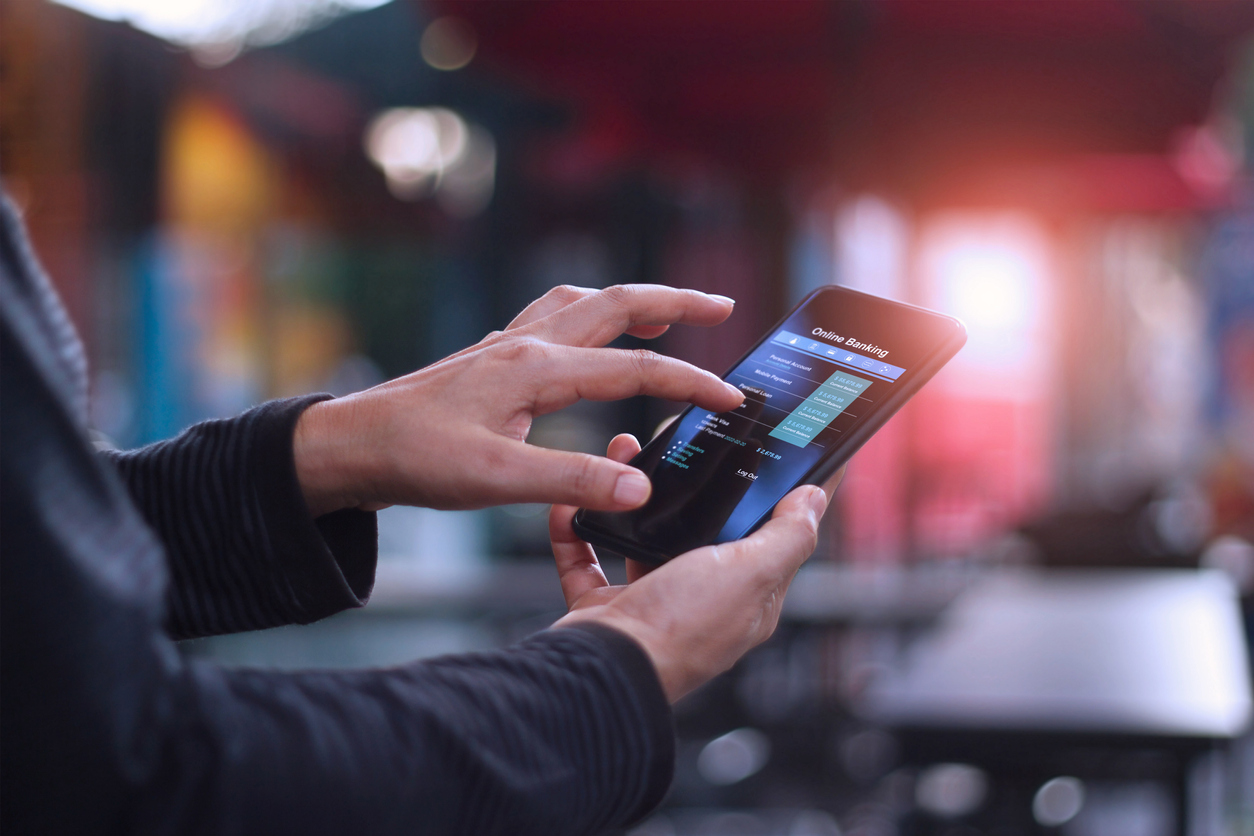 Man with smartphone online banking in a cafe