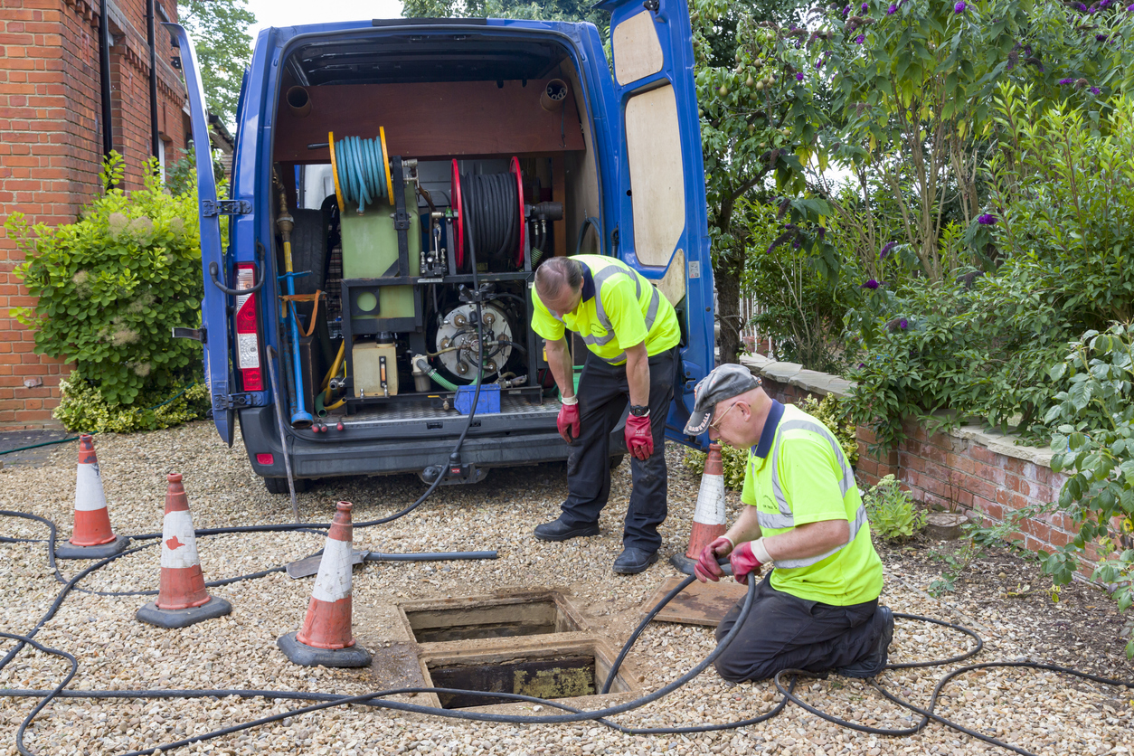 Workmen unblocking a drain in Buckingham, England