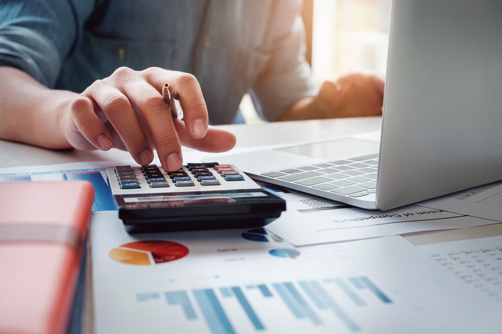 Accountant with calculator using laptop