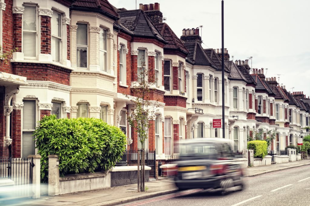 Black cab driving in a London residential street