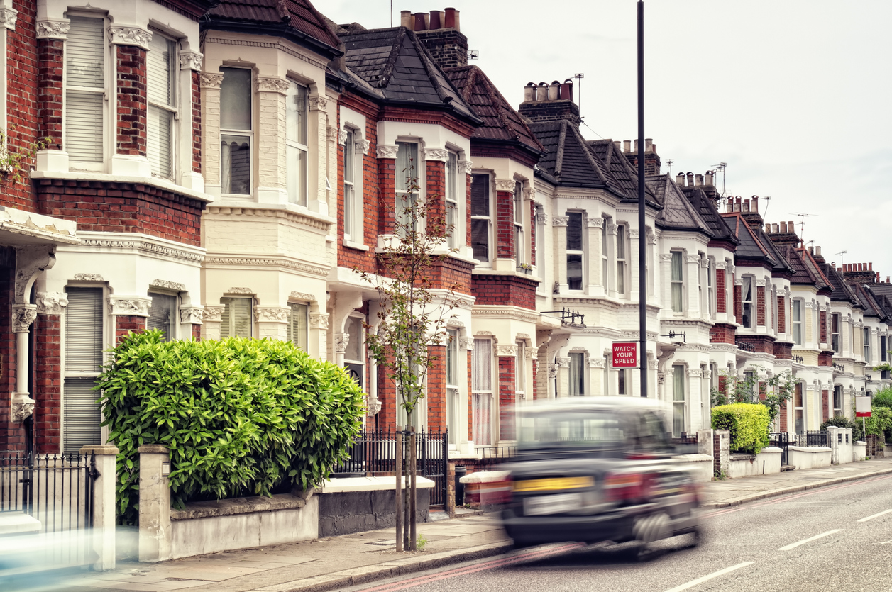 Black cab driving in a London residential street