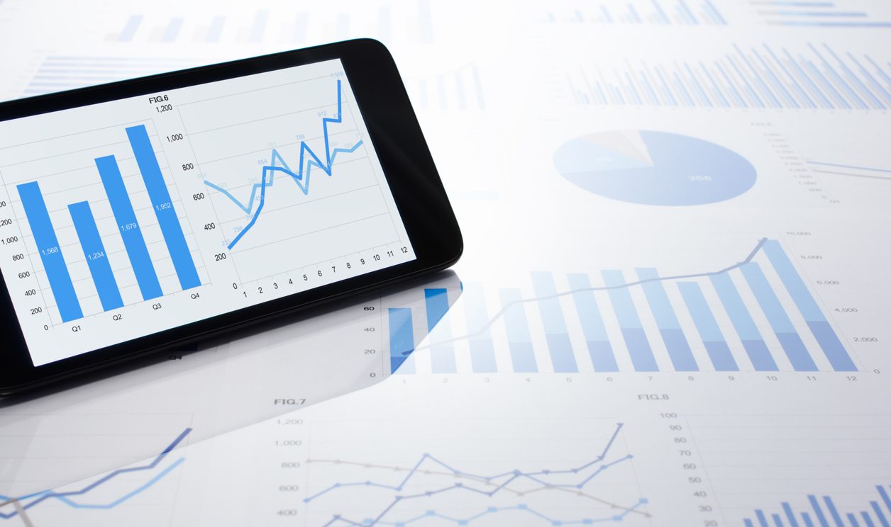 Business data displayed on smartphone and charts
