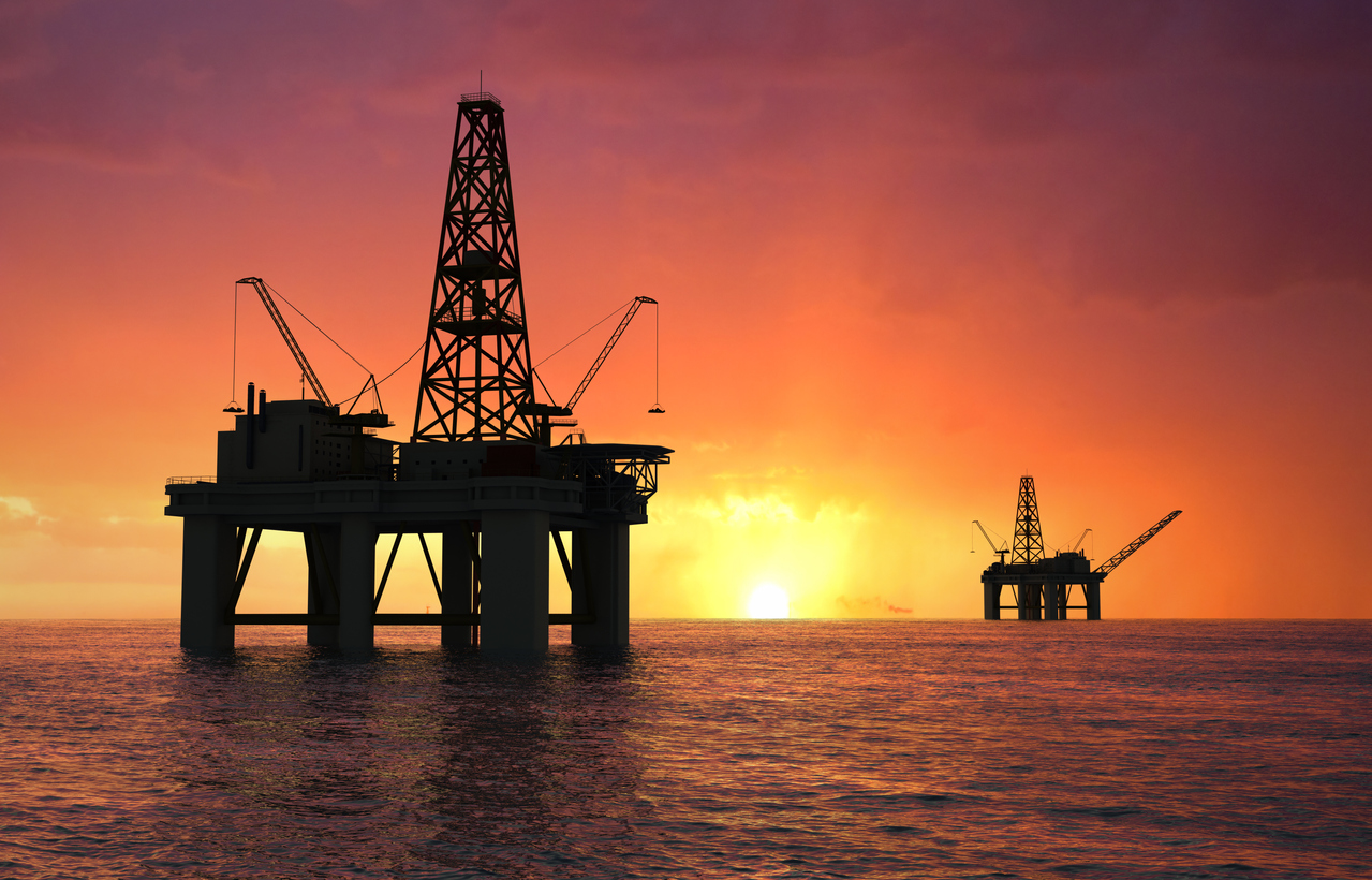 Oil rig silhouettes at sunset
