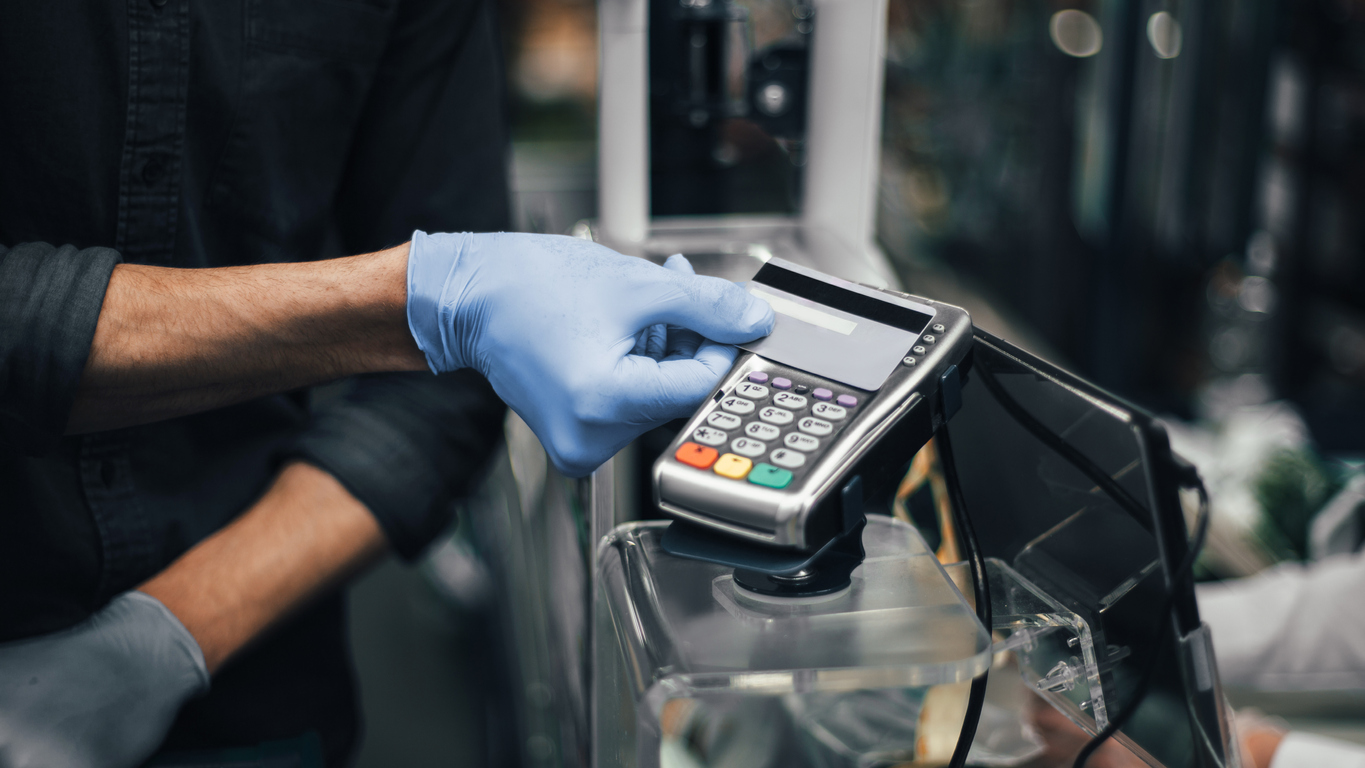 Man wearing gloves making contactless payment