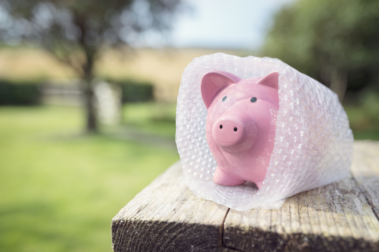 Piggy bank wrapped in bubble wrap, disaster-proofing your finances