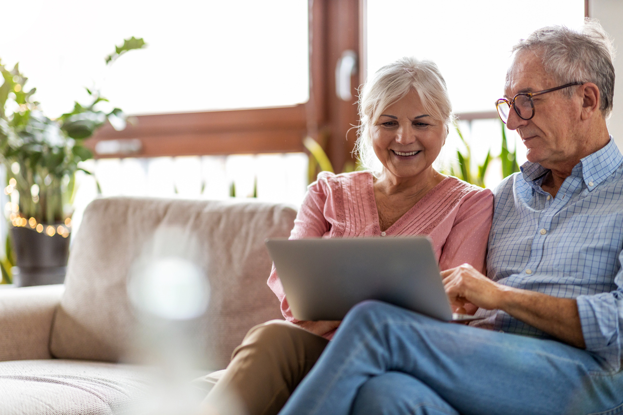 Older couple looking at their finances on laptop