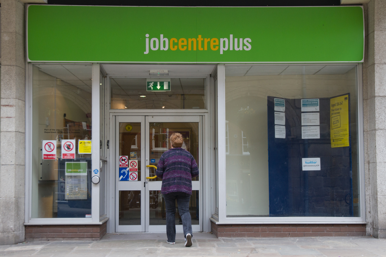 Woman walks towards job centre as UK unemployment rates improve
