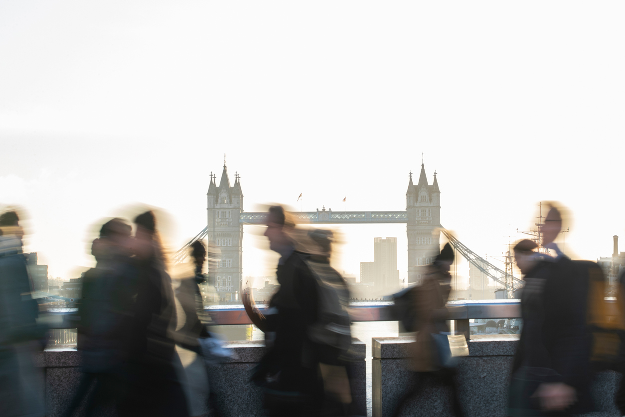 Commuters walking past Tower Bridge, London, UK.