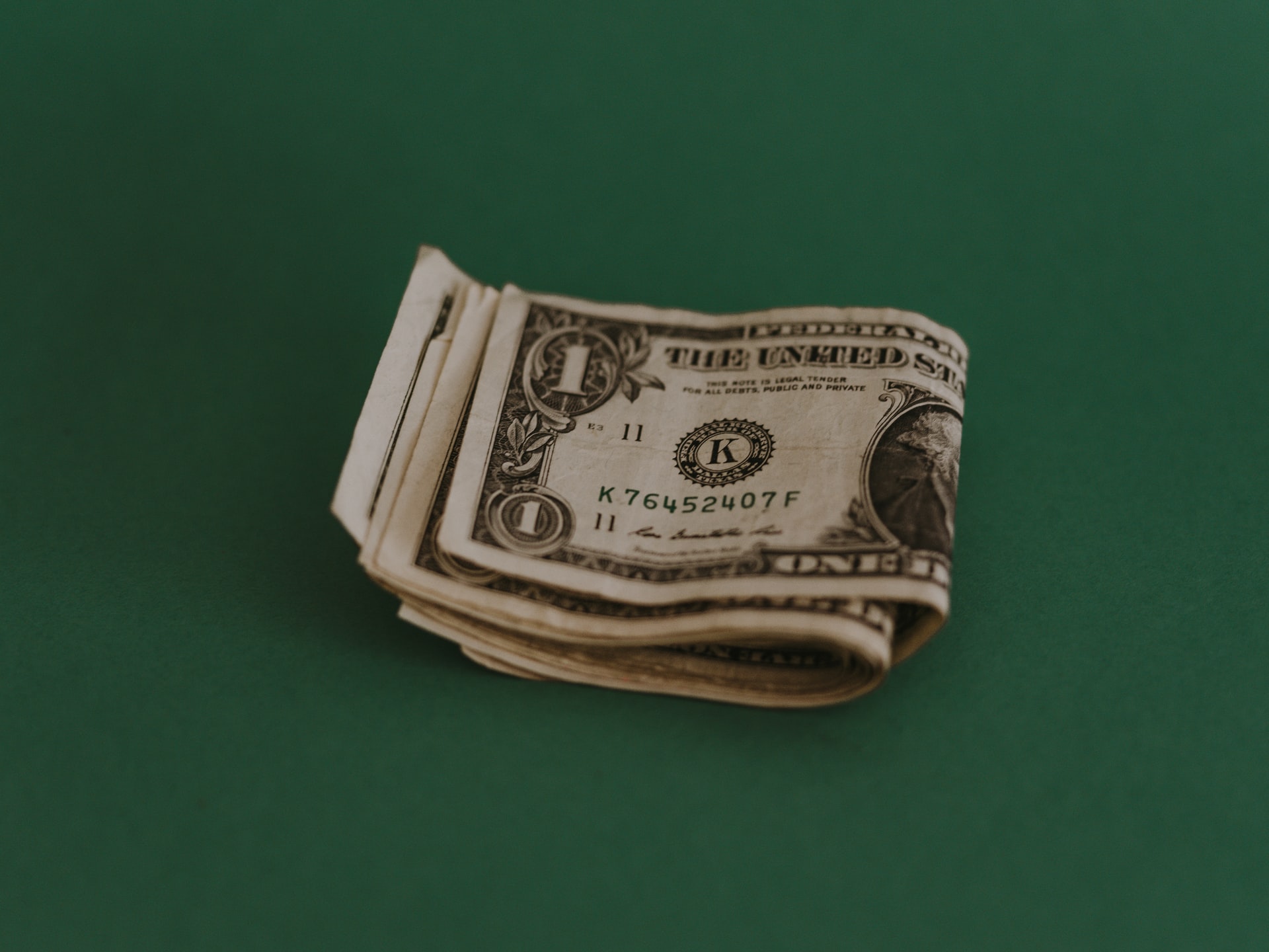 Wad of cash on green background