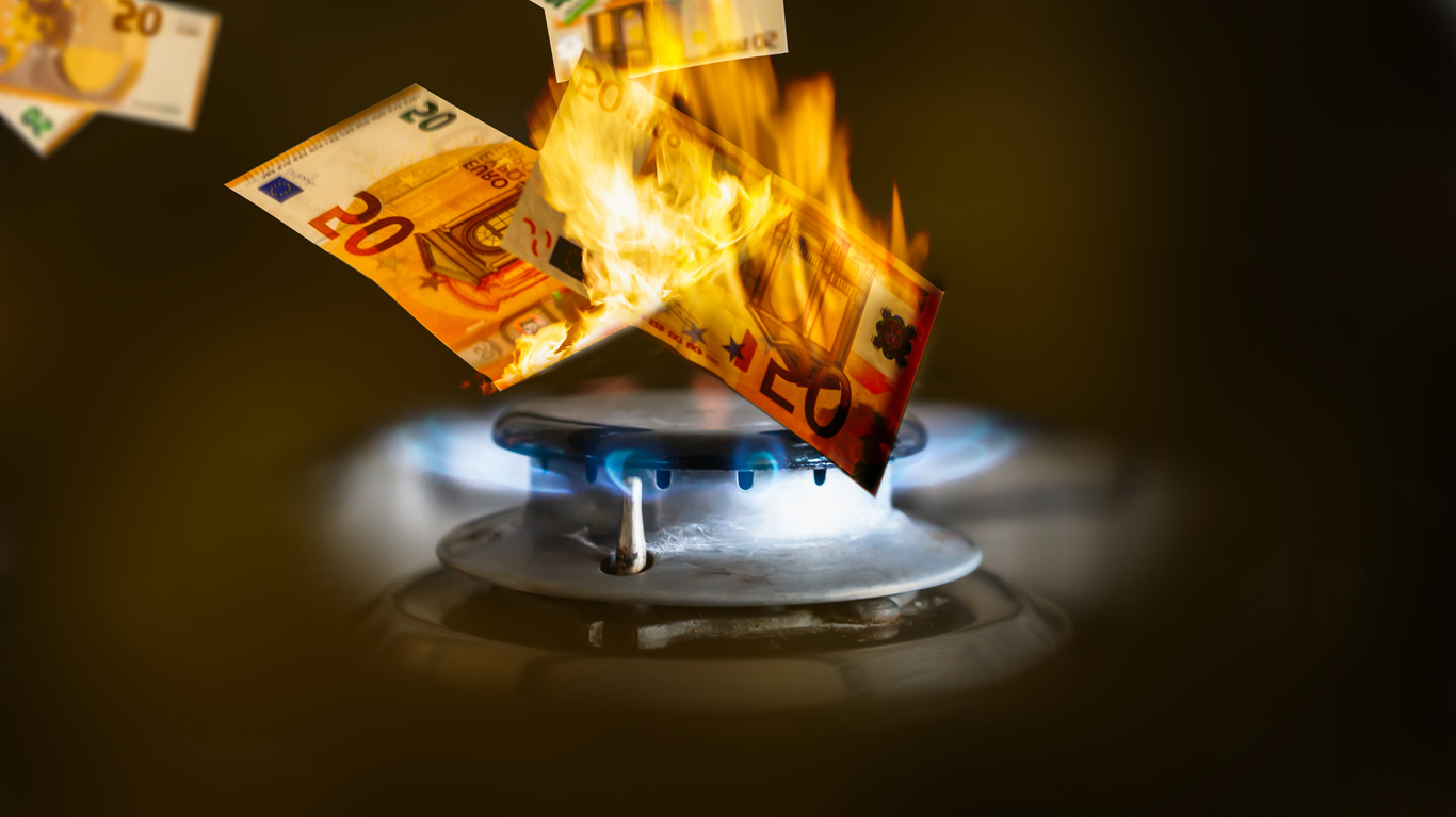 Bank notes burning on gas flame; cost of living crisis