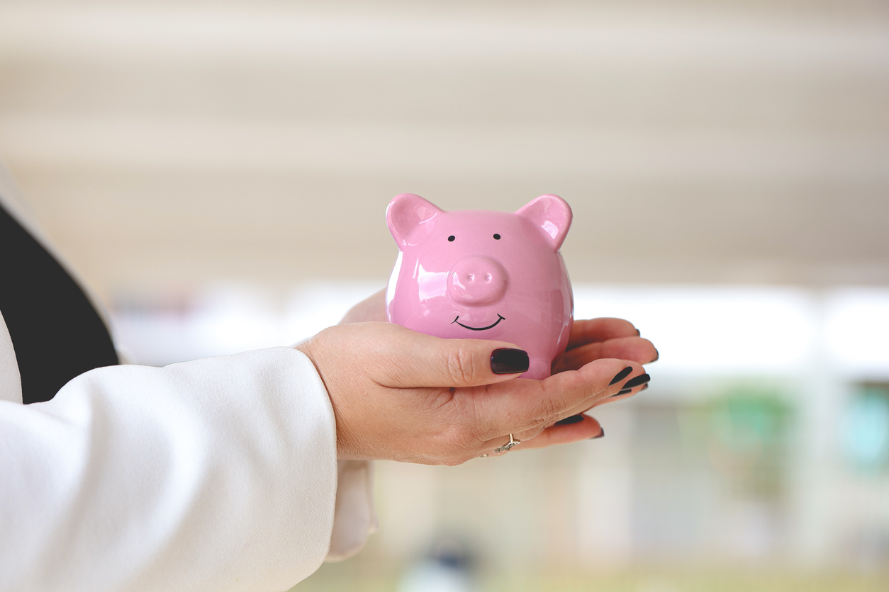 A business woman holding a piggy bank. Economy and finance.