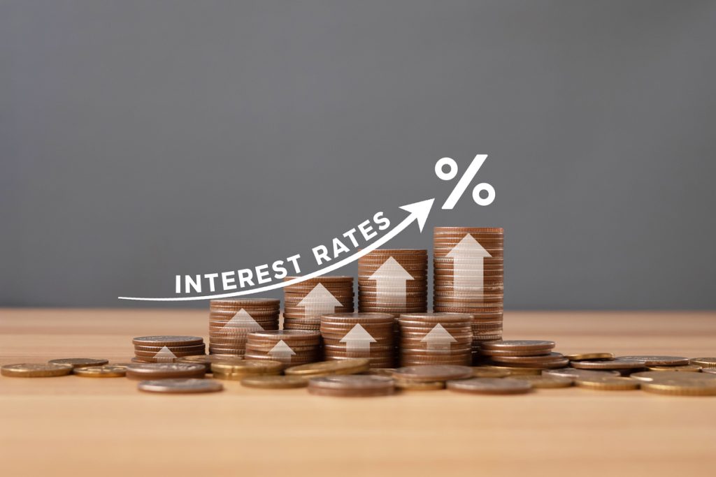 stacked of coins on table with percentage icon and gray background with illustration shows increasing of interest rates / financial concept.