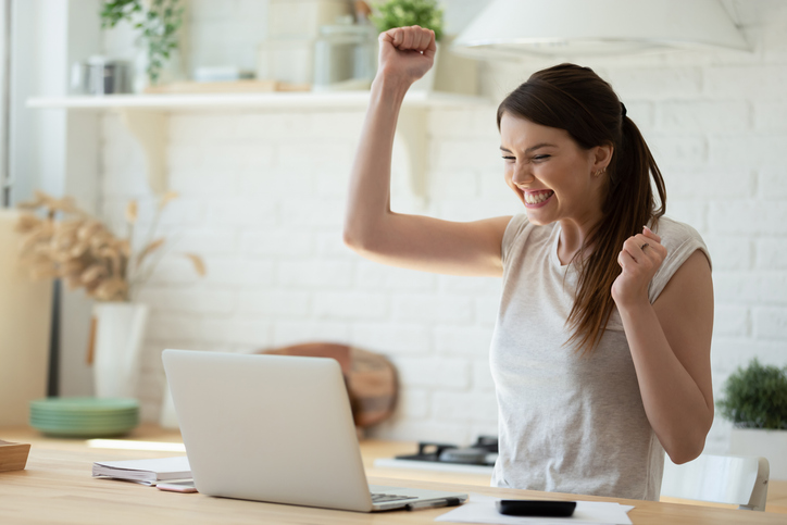 young woman with laptop delighted by salary increase