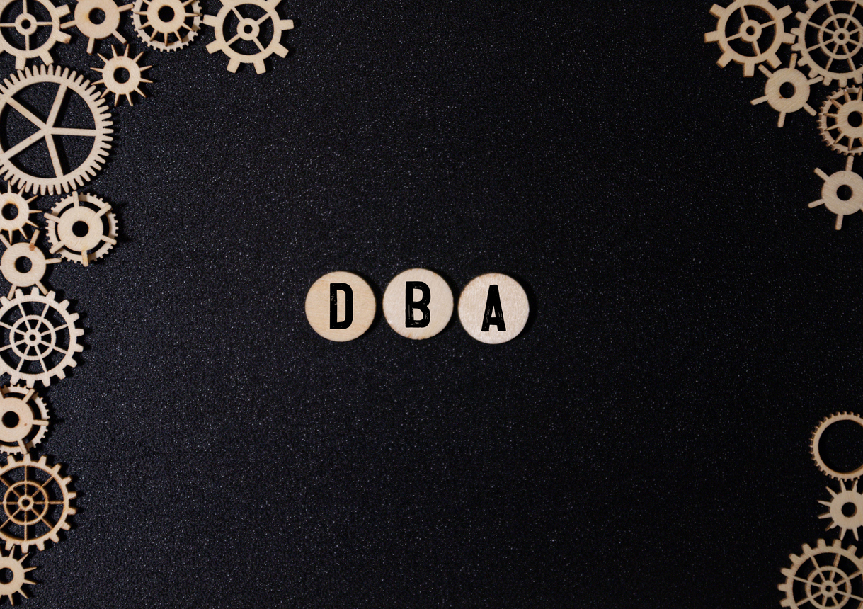 dba text assembled from wooden cubes on a black background