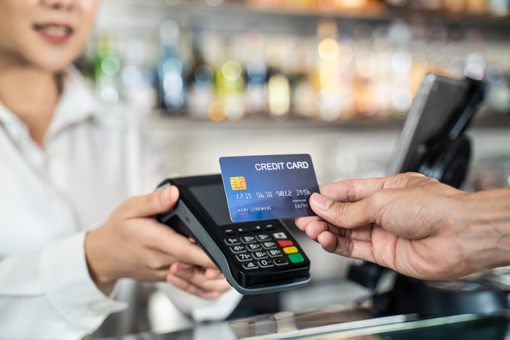 close up shot of customer hand using dummy credit card for payment to waitress at cashier in cafe restaurant, money cashless and credit card payment technology concept.