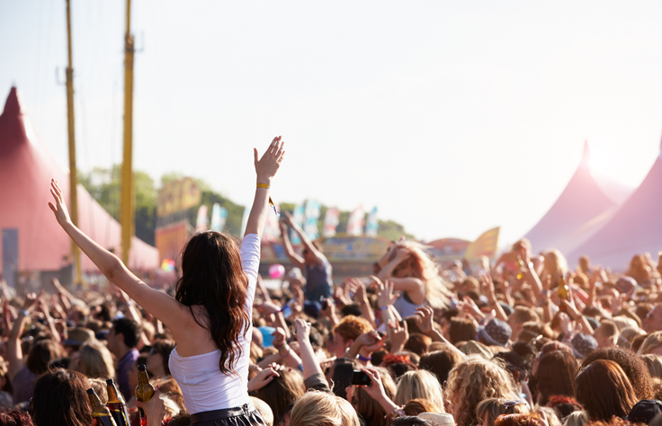 people with their arms in air at music festival