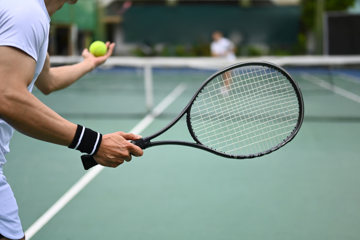 tennis player serving tennis ball during a match on open court. sport, training and active life concept.