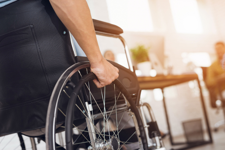 a disabled man is sitting in a wheelchair.