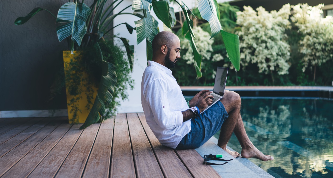 side view of skilled businessman using laptop device for making online ticketing and banking during resort recreation on bali island, middle eastern digital nomad connecting to villa wifi on netbook