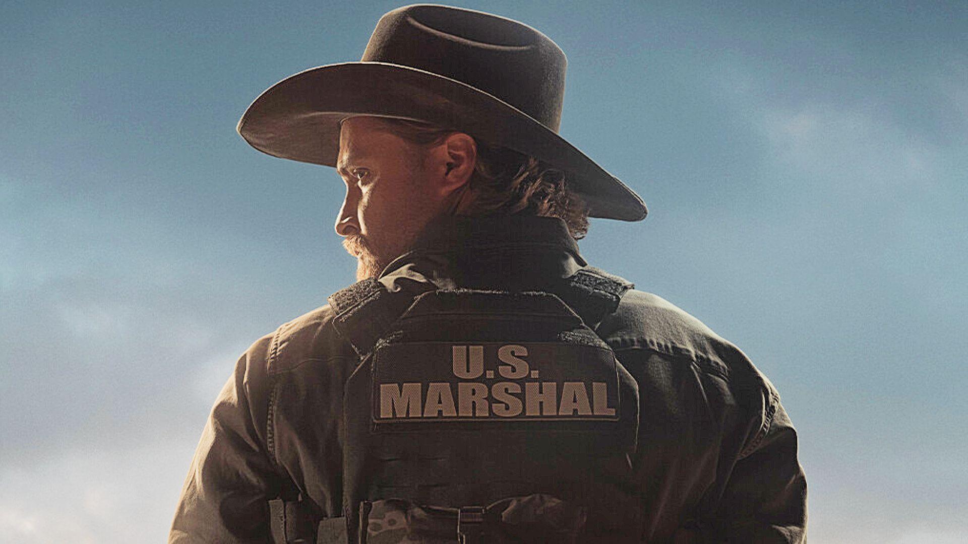 Luke Grimes portraying a U.S. Marshal in the upcoming Marshals series, wearing tactical gear and ready for law enforcement duties.