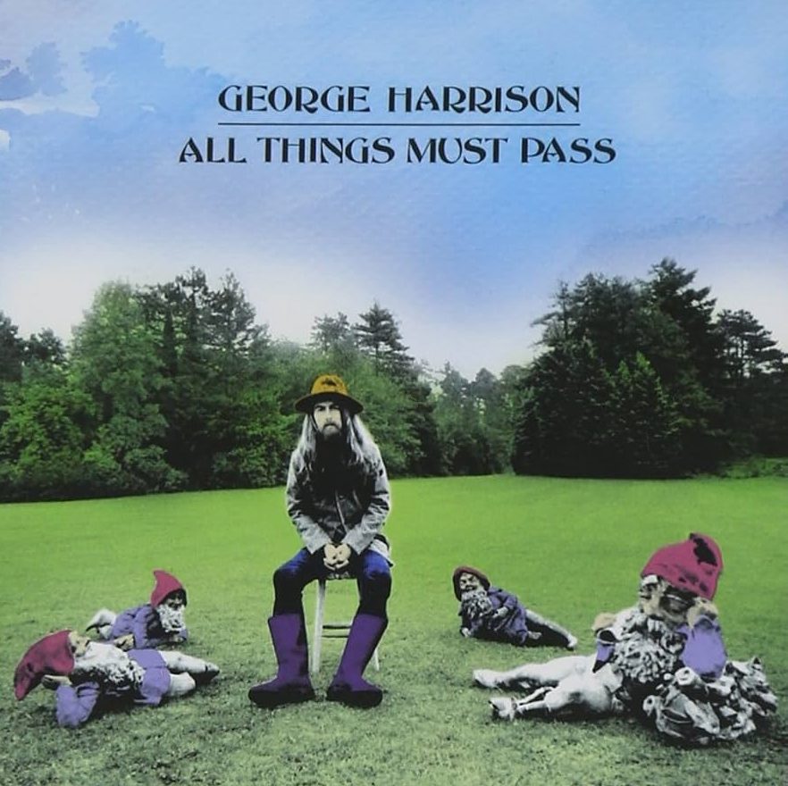 George Harrison sits on a stool in a grassy field surrounded by four garden gnomes, wearing a wide-brimmed hat and purple boots, with the album title “All Things Must Pass” above him.