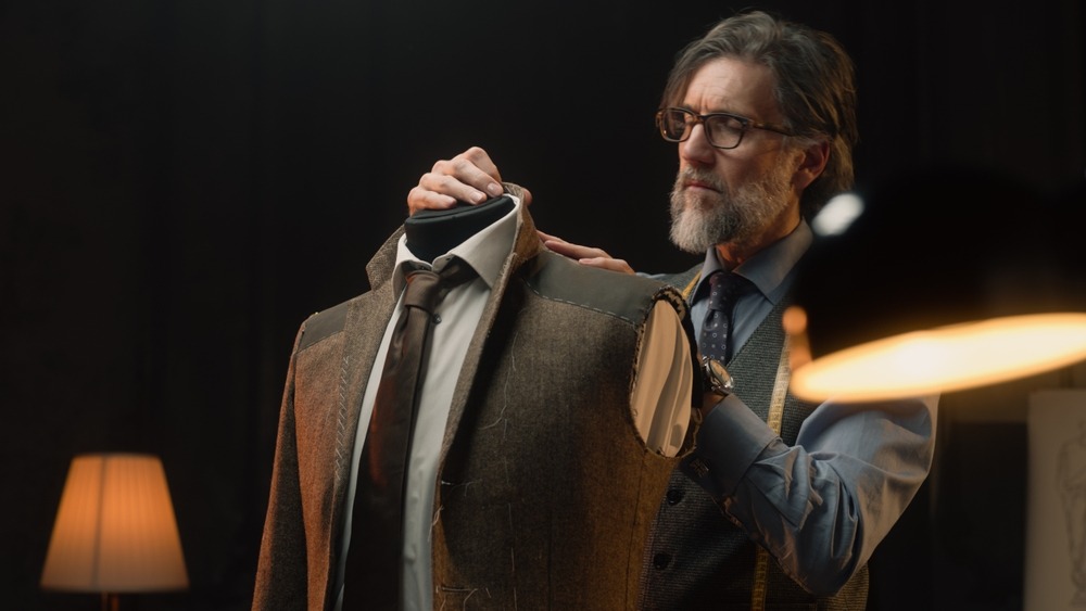 male,mature,tailor,works,on,elegant,business,or,wedding,suit.