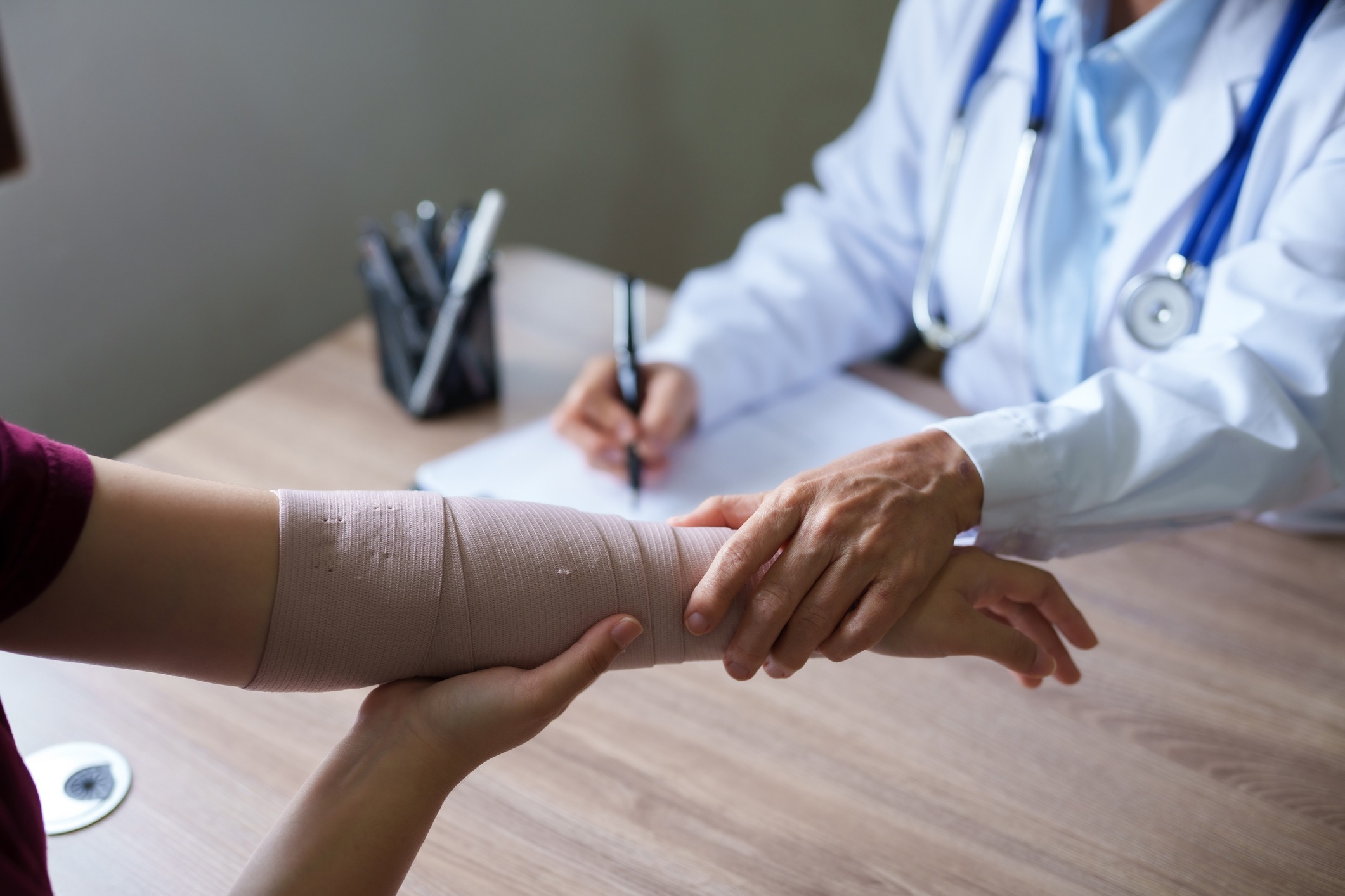 doctor is examining the arm of a female patient who has been in an accident.