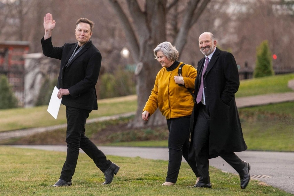 tesla,ceo,elon,musk,(l),waves,as,he,walks,with