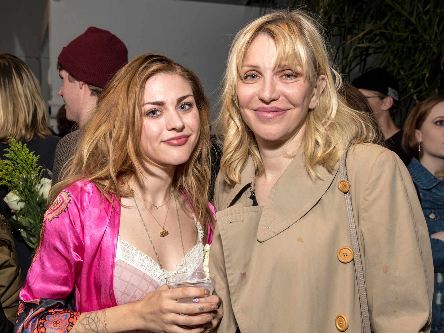 Courtney Love and her daughter Frances Bean Cobain posing together on the red carpet, dressed elegantly and smiling for photographers.