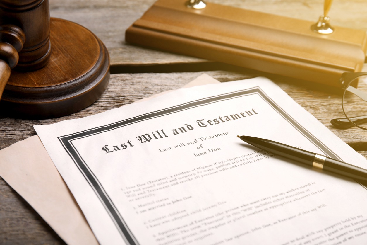 last will and testament, pen and gavel on wooden table, closeup