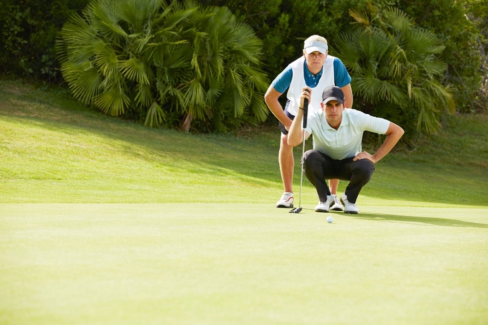 caddy,and,golfer,preparing,to,putt