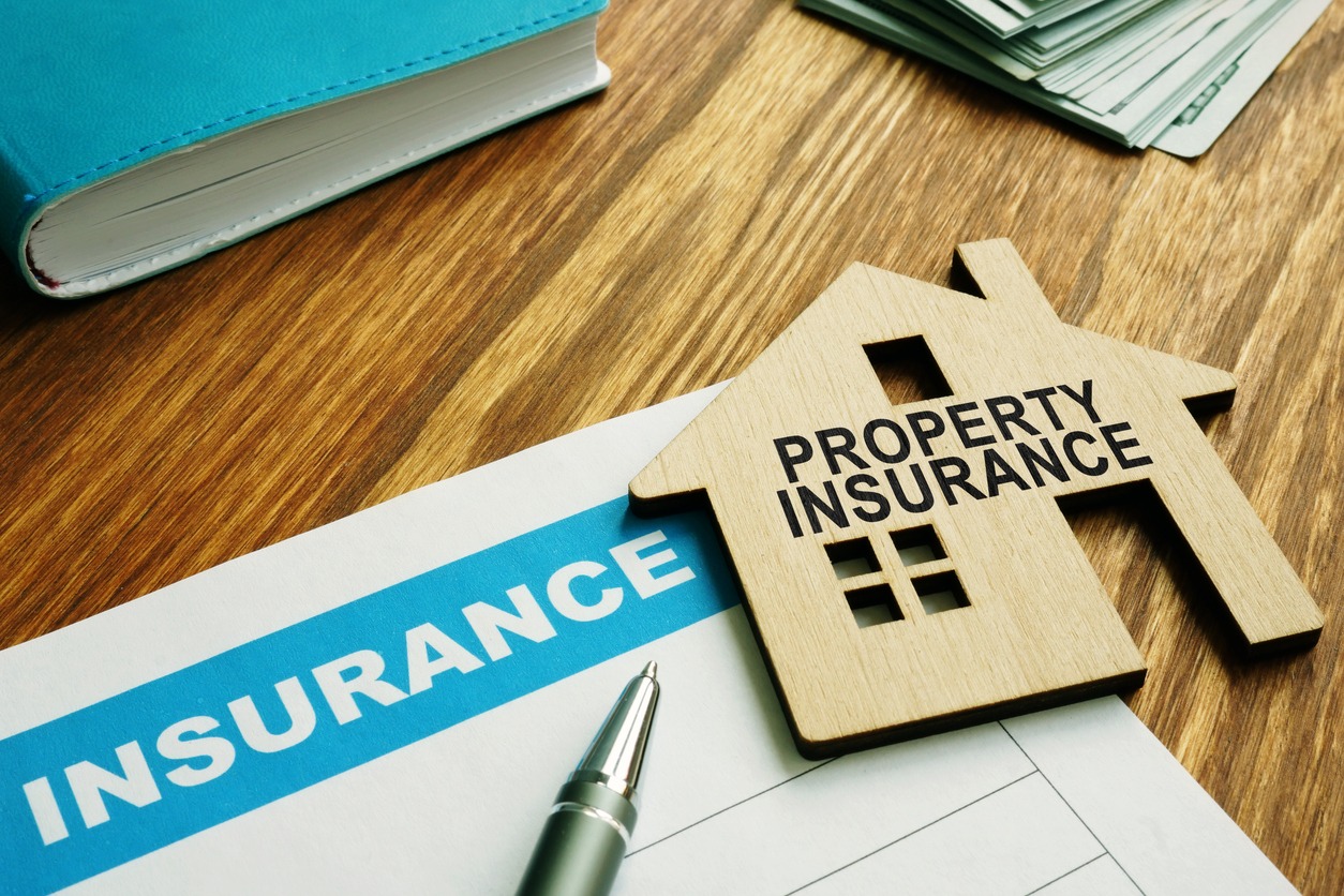 property insurance stamp on a model wooden home.