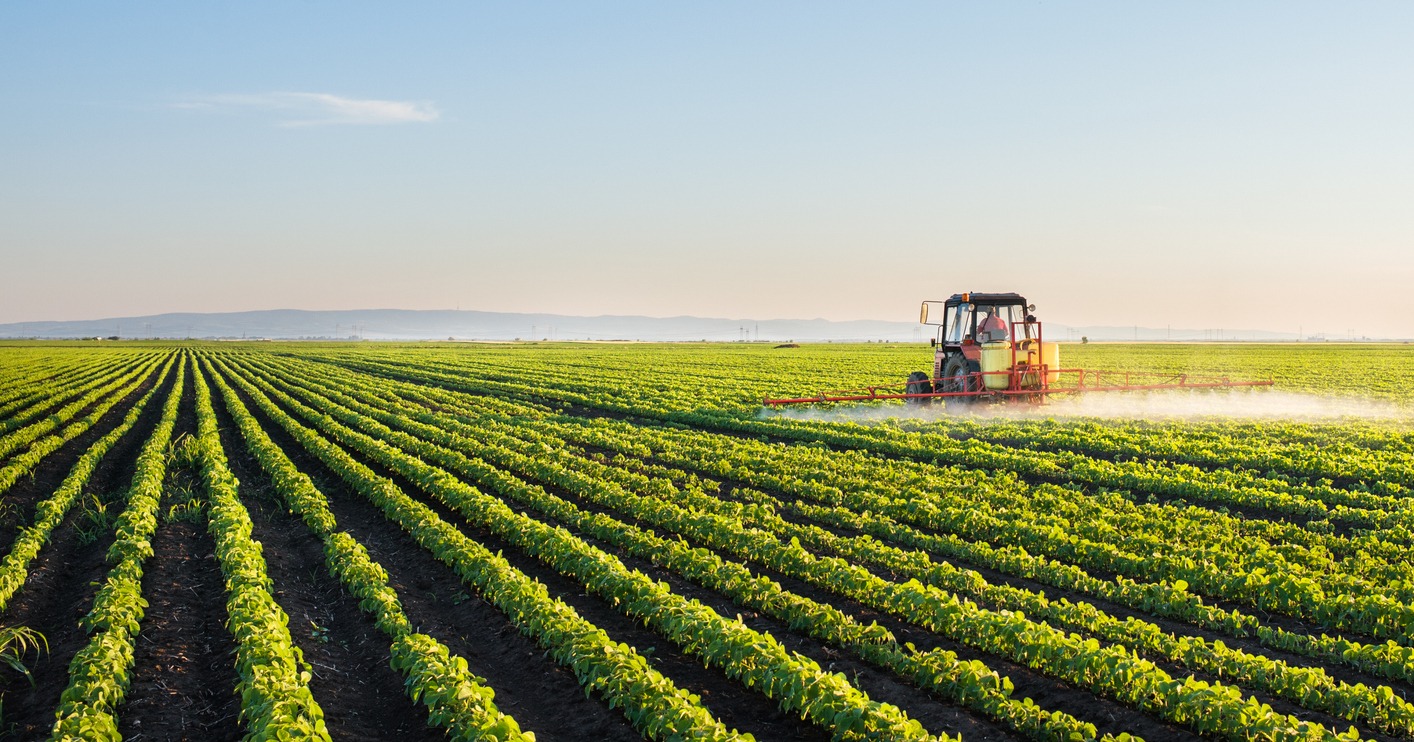 tractor spraying soybean field