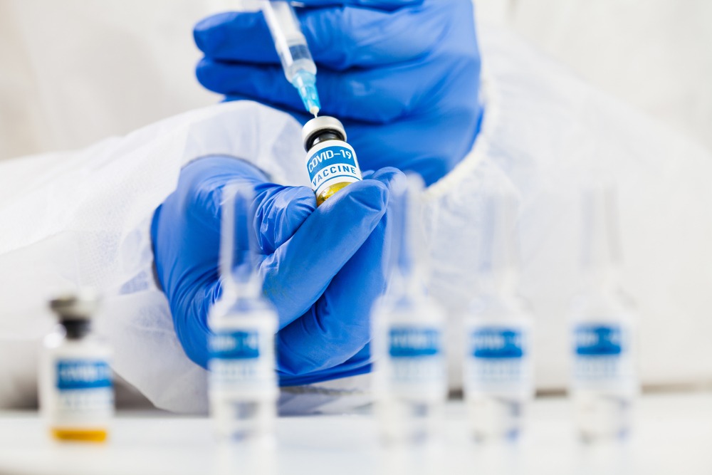 lab,scientist,holding,syringe,and,covid 19,vaccine,ampoule,cure,medication,treatment