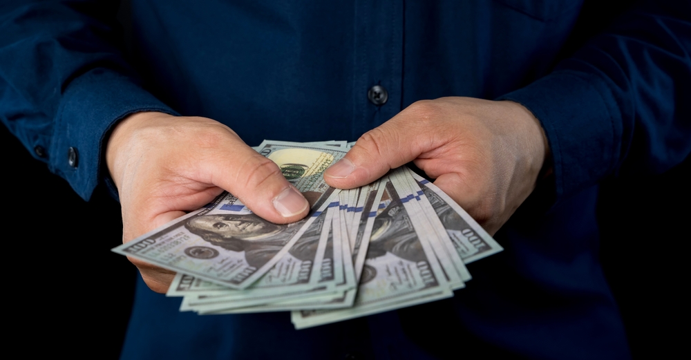 big,pile,of,money,dollars,in,the,hand.,close,up