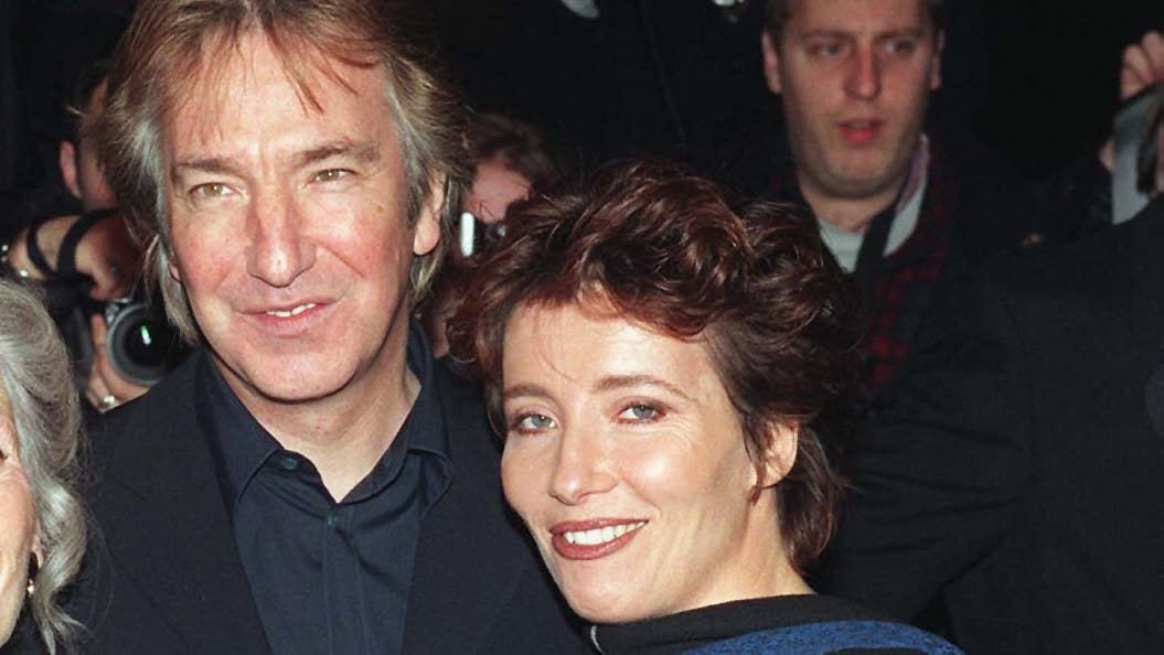 Alan Rickman and Emma Thompson posing together on the red carpet, both smiling and dressed elegantly.