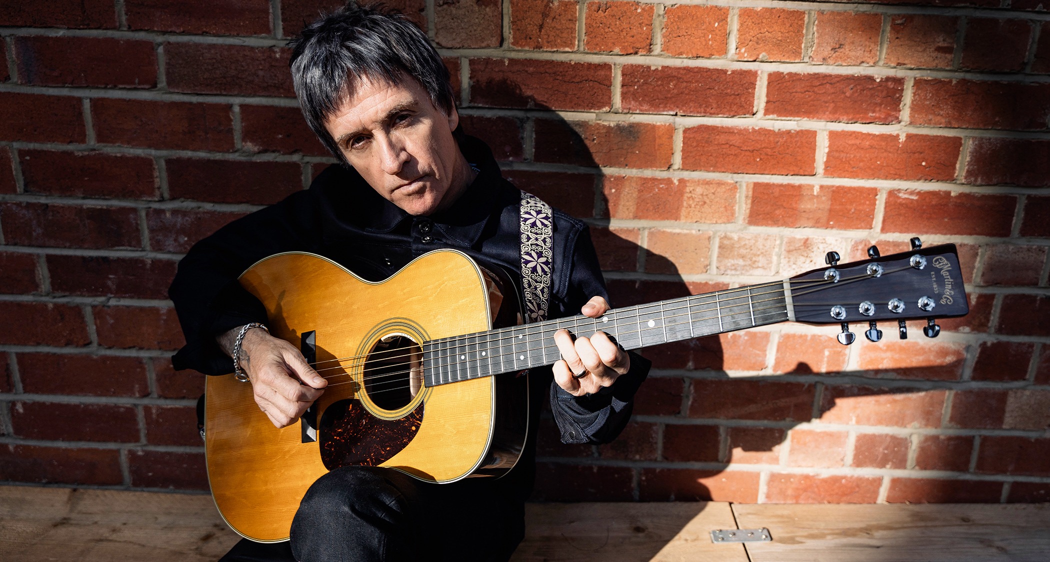 Johnny Marr net worth 2025 guitarist performing with Rickenbacker guitar live concert"