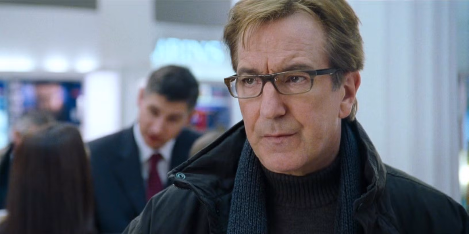 Alan Rickman as Harry in Love Actually, wearing a turtleneck with a contemplative expression.