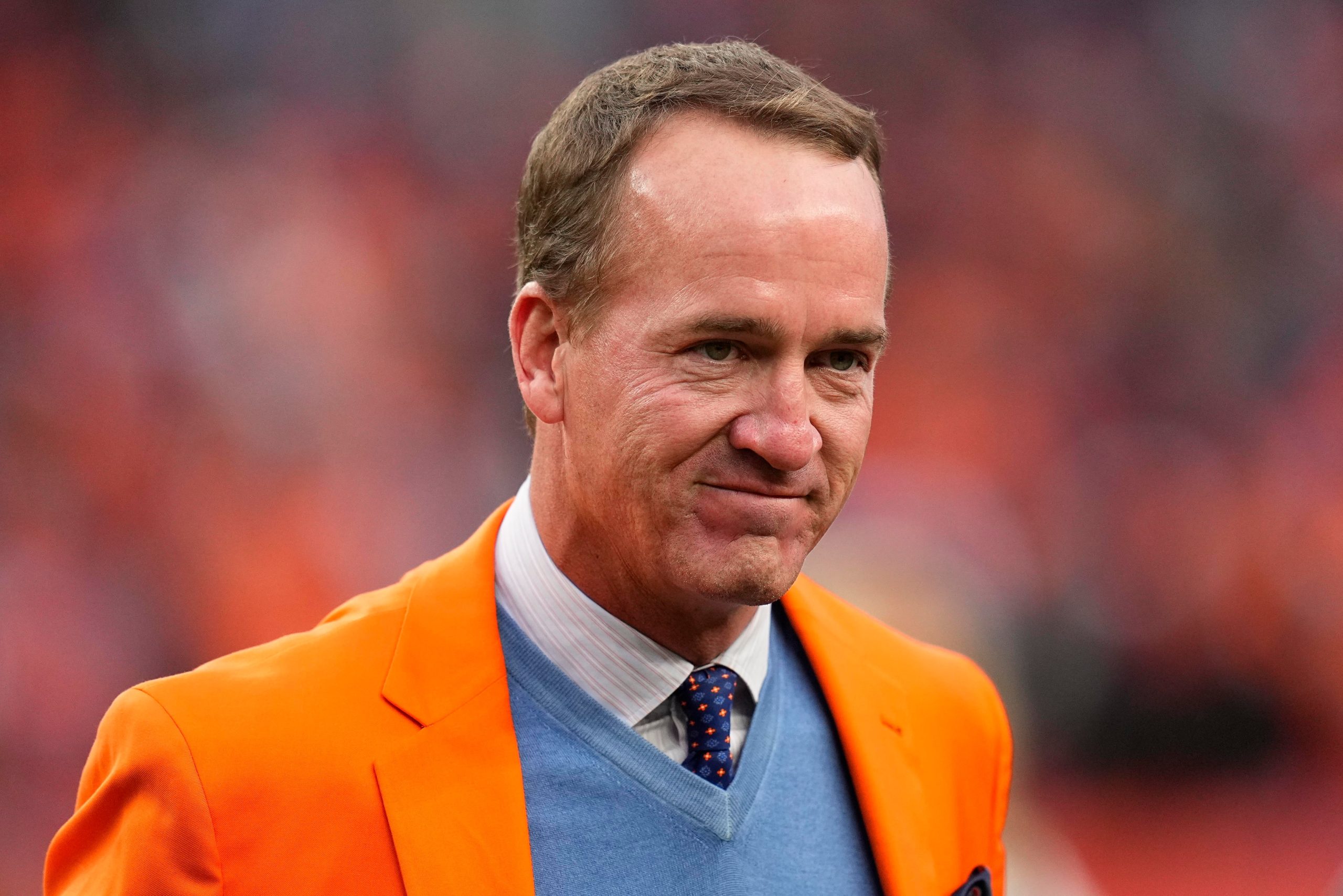 Peyton Manning smiling in suit 2025
