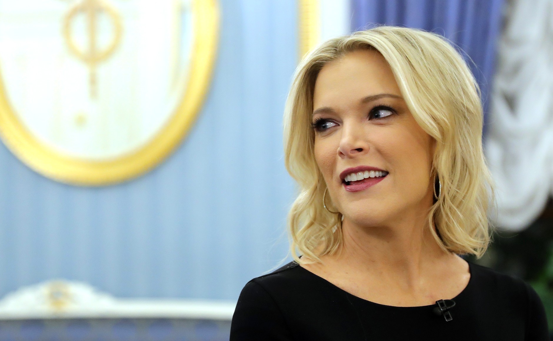 Megyn Kelly smiling warmly inside the White House, dressed in formal attire.