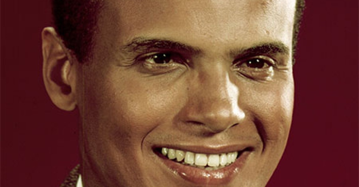 Harry Belafonte smiling in 1950s promotional photo during peak of calypso music career
