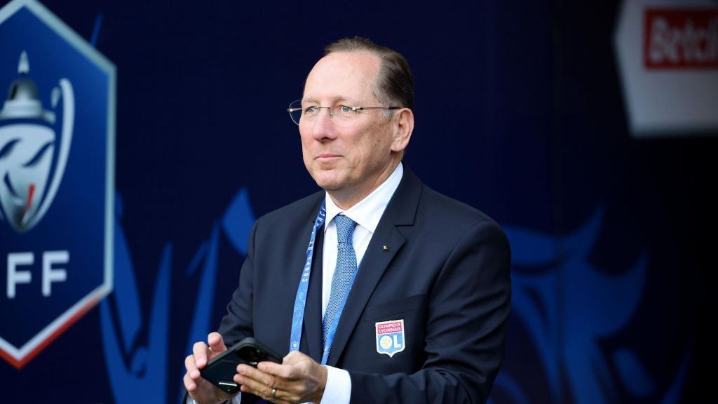 John Textor dressed in an official Olympique Lyonnais suit, looking confident and professional at a formal club event.