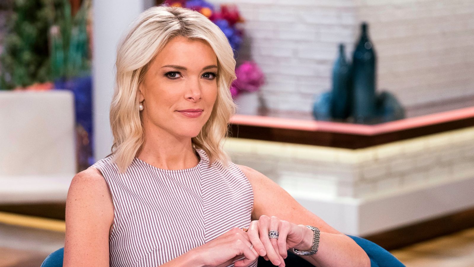 Megyn Kelly sitting on a talk show set, smiling during a live interview.
