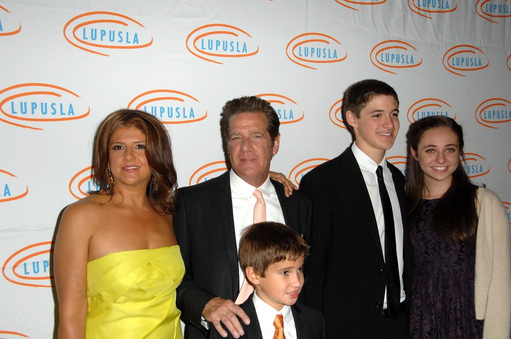 Glenn Frey standing on the red carpet with his family, dressed elegantly and smiling for the cameras at a high-profile event.