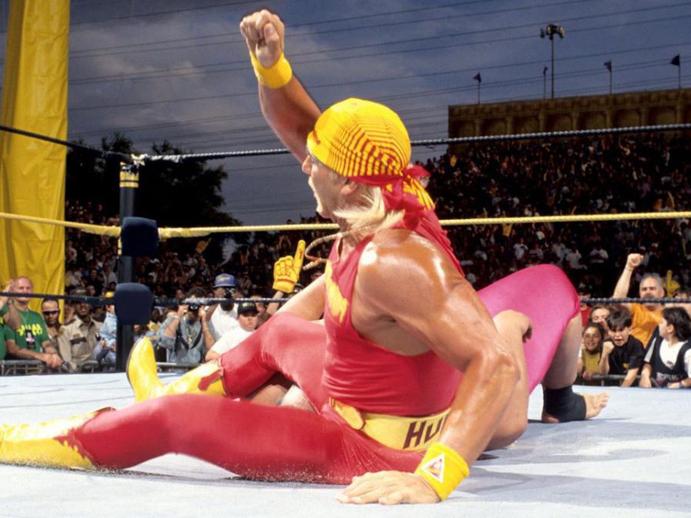 Hulk Hogan executing his iconic leg drop finishing move in the wrestling ring.