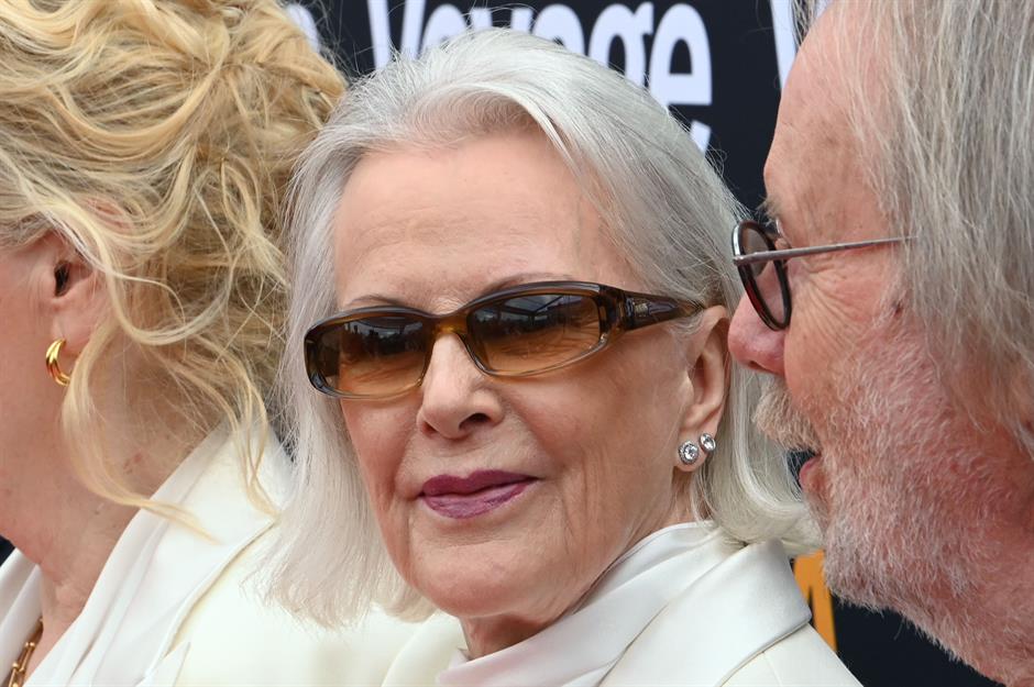 Anni-Frid Lyngstad wearing stylish sunglasses, looking directly at the camera on the red carpet at the ABBA Voyage premiere.